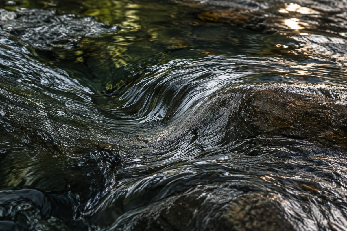 Illustrative water flowing over dark stone